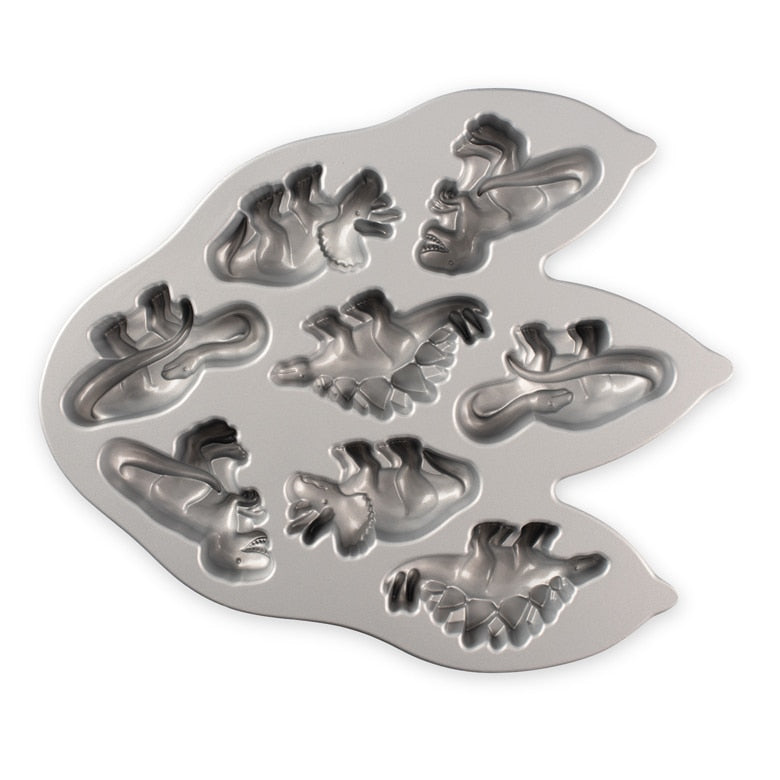 Nordic Ware | Dinosaur Cakelet Pan: Metal mold with dinosaur shapes for baking 8 muffins or cakes, featuring nonstick cast aluminum for easy release.