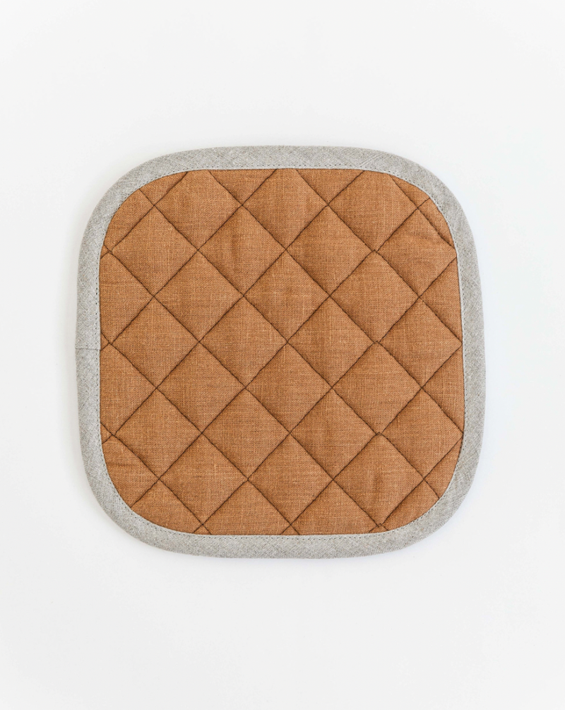 Linen pot-holder with quilted detailing, ideal for heat protection in the kitchen. Features hanging loop, approximately 8x8 inches. MagicLinen brand, available in various colors.