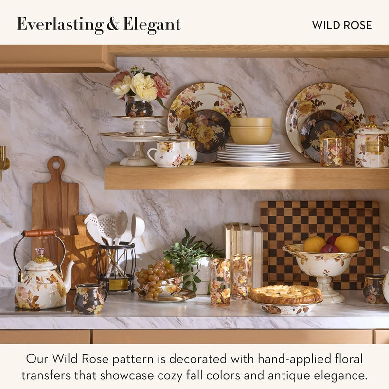 Mackenzie Childs White Wild Rose Tea Kettle, 2 QT, with floral design and wooden handle, displayed with matching dinnerware and kitchen accessories on styled shelves.