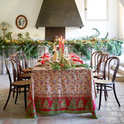 Couleur Nature - Noel Red & Green French Tablecloth elegantly adorns a festive dining table, featuring Christmas tree patterns amidst holiday decor with candles and greenery.