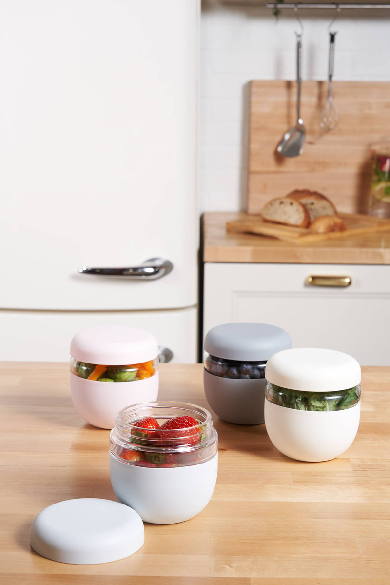 W&P Glass Seal Tight To-Go & Storage Bowl: Cream / 16 oz, shown among jars and containers, highlighting its secure, leak-proof lid and eco-friendly design.
