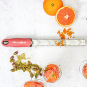 Microplane | Premium Zester, Grater - Lipstick Pink zesting citrus beside pistachio-topped sorbet, illustrating its precision and versatility in culinary preparation.