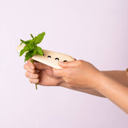 Collin Garrity - Herb Stripper: Cherry being used to strip mint leaves from a stem, showcasing its efficient design with multiple hole sizes for versatile herb preparation.