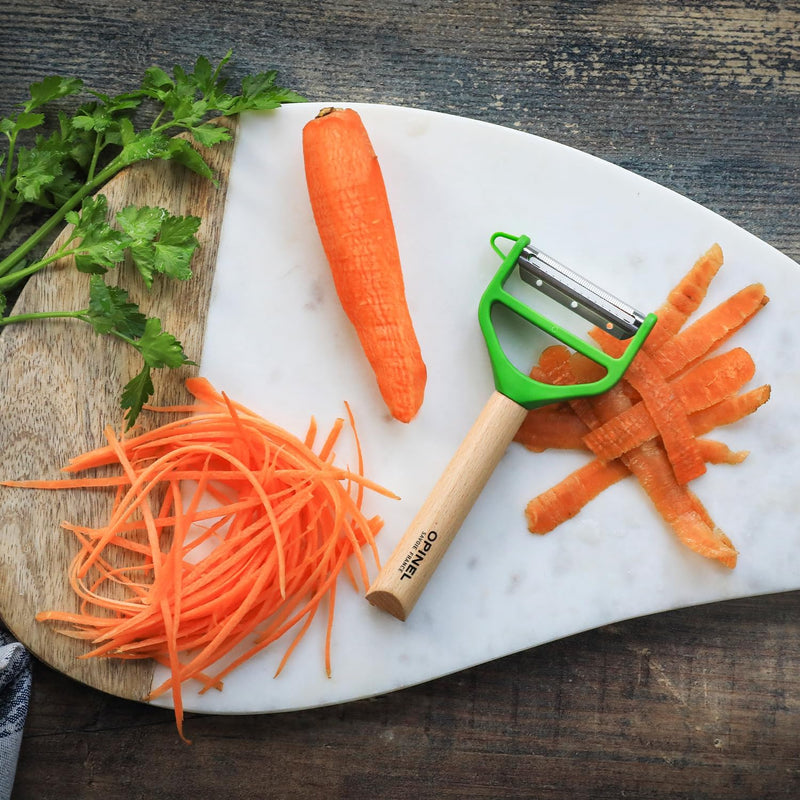 Opinel | T Duo Peeler with Wooden Handle, Green, shown with julienned carrots and peelings on a two-tone board, highlighting its dual peeling and julienning features.