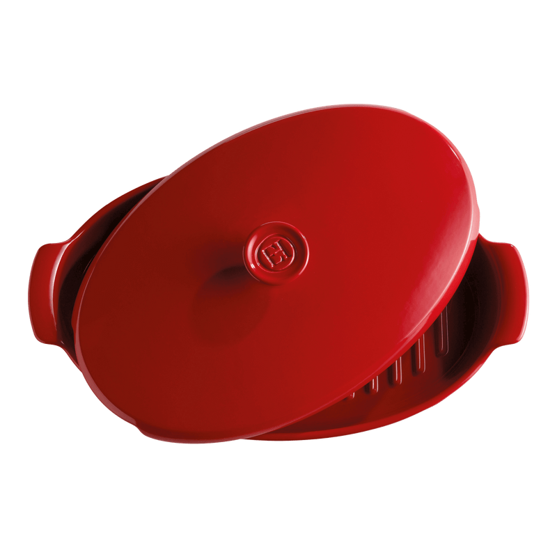 Emile Henry small oval baking dish with lid, showcasing shallow base ridges for even cooking, crafted from Burgundy clay, ideal for casseroles or roasts.