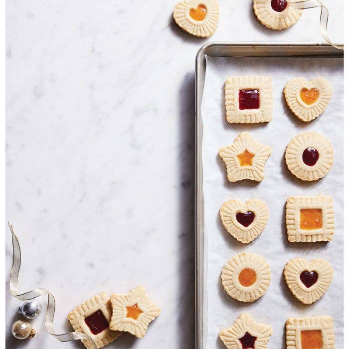 HIC - Harold Import Co. - King Arthur Thumbprint Cookie Cutters 4-Piece Set creates embossed, center-filled cookies in heart, star, square, and round shapes on a baking sheet.