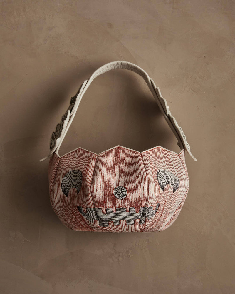 Coral & Tusk - Jack-o'-Lantern Basket, a stitched fabric tote resembling a smiling pumpkin, perfect for Halloween treats with intricate embroidery and appliquéd leaves.