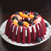 Nordic Ware | Brilliance 10-Cup Bundt Pan showcasing a red fruit-topped cake, highlighting its elegant design and perfect for baking enthusiasts.