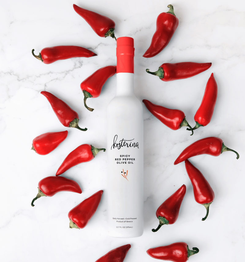 Kosterina - Spicy Red Pepper Olive Oil (375ml) bottle surrounded by red peppers, highlighting its subtle, spicy flavor perfect for enhancing various dishes.