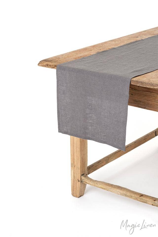 MagicLinen table runner on a wooden table, showcasing its elegant design and functionality for enhancing dining settings, available in various sizes and colors.