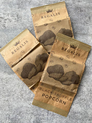 Regalis Foods | Microwave Black Truffle Popcorn Box: Three kraft-paper bags of gourmet popcorn featuring European Black Truffles, perfect for indulgent snacking or gifting.