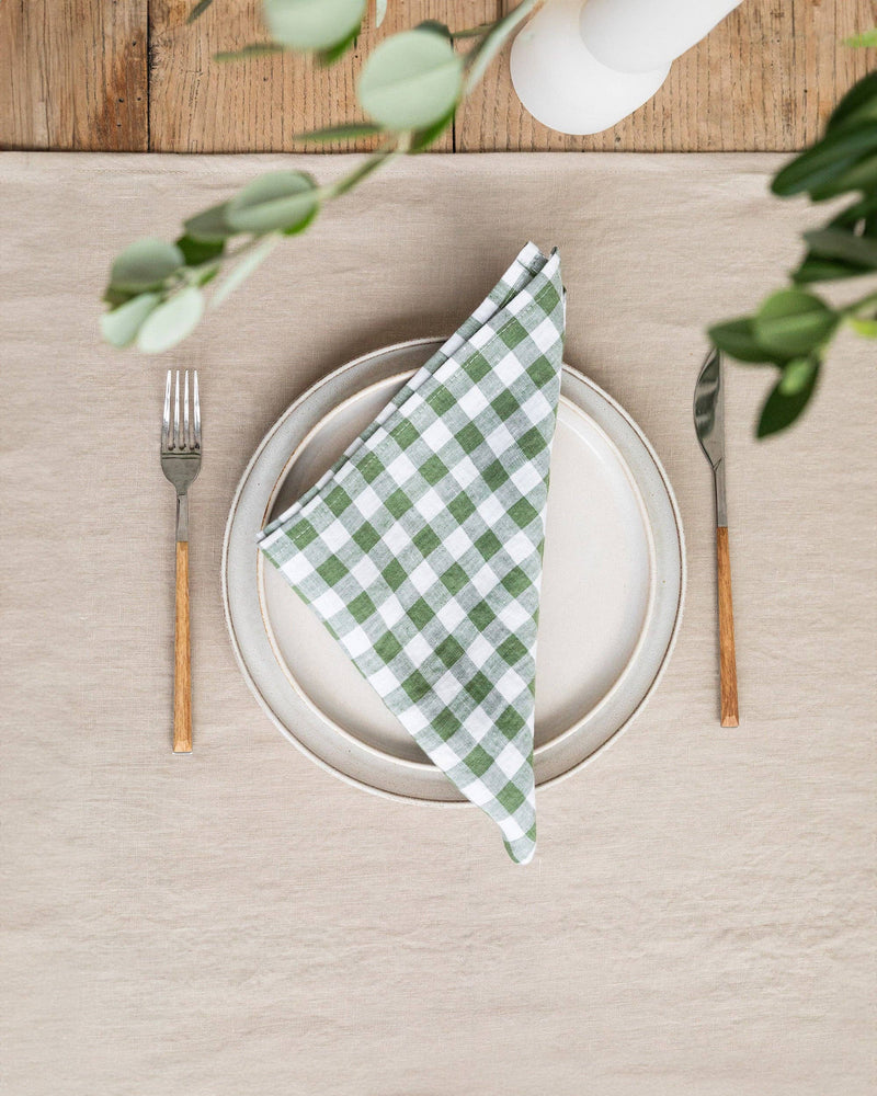 MagicLinen - Forest green gingham linen napkin set of 2 elegantly displayed on a plate, highlighting their soft texture and perfect size for dining occasions.