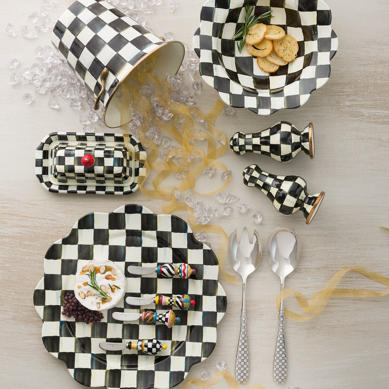 Courtly Check Butter Box by MacKenzie-Childs displayed in a checkered tabletop setting with matching kitchenware, emphasizing its hand-painted design and elegant brass accents.