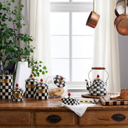 MacKenzie-Childs Courtly Check Butter Box on rustic counter with bread, cookies, and copper pans, showcasing a cozy Athens Cooks kitchen scene.
