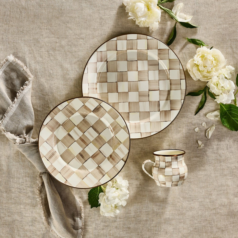 MacKenzie Childs | Mocha Check Mug on a rustic table setting with matching ceramic plates, fringed linen napkin, and scattered white blooms.