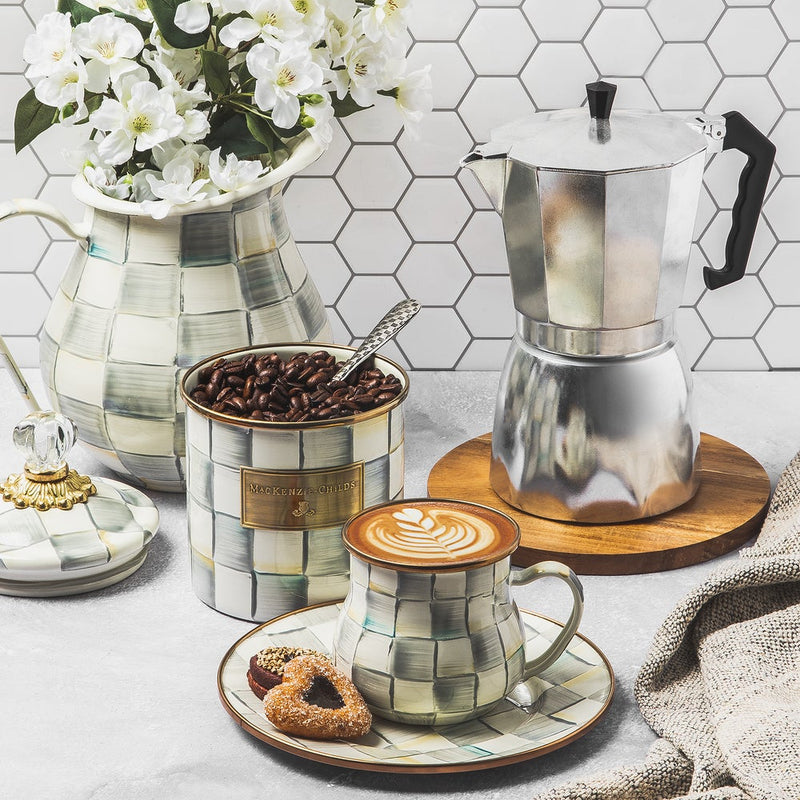 MacKenzie-Childs Sterling Check Small Canister filled with coffee beans and spoon, part of a decorative coffee setup with a moka pot and check-patterned accessories.