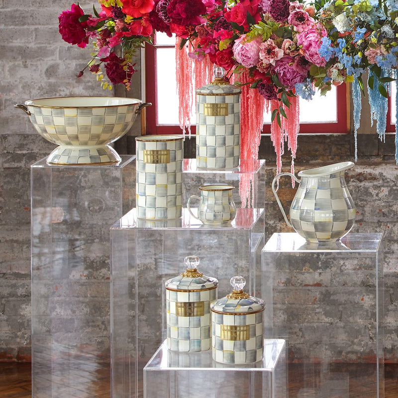 Sterling Check Medium Canister displayed with other ceramic tableware on pedestals, featuring hand-painted checks and a glass knob, in a curated kitchen setting.