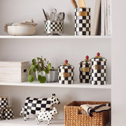 Courtly Check Large Canister by MacKenzie Childs displayed on a shelf, surrounded by matching kitchenware, emphasizing its versatile storage capabilities in a curated kitchen setting.