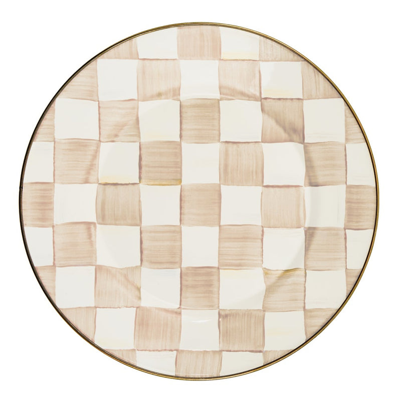 MacKenzie Childs | Mocha Check Dinner Plate features a hand-painted beige and off-white checkerboard pattern with a bronzed stainless steel rim, exemplifying artisanal craftsmanship.