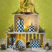 MacKenzie Childs Royal Check Wood Paper Towel Holder with blue and white checkered enamel, wood base, stainless-steel post, and blue glass finial displayed with recipe cards.