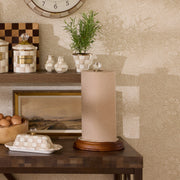 MacKenzie Childs Mocha Check Wood Paper Towel Holder on a shelf, featuring a wooden base, stainless-steel center, and a clear glass finial.