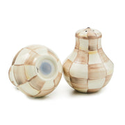 MacKenzie Childs | Mocha Check Salt & Pepper Shakers showcasing hand-painted checker pattern, one upright and one tilted, highlighting their craftsmanship and unique design.
