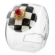 MacKenzie-Childs Cookie Jar with Courtly Check Lid features a clear glass body and a hand-painted checkerboard ceramic lid topped with a decorative gold floral rosette.