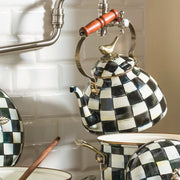 MacKenzie Childs | Courtly Check with Bird Tea Kettle, 3 QT, featuring a checkerboard pattern and brass bird knob, under a pot-filler faucet in a kitchen setting.