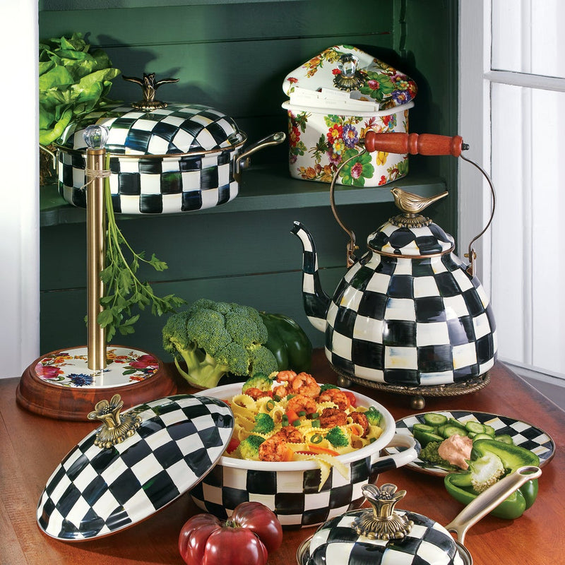 MacKenzie-Childs Courtly Check with Bird Tea Kettle, 3 QT, features black-and-white checkerboard design with a bird finial, surrounded by matching kitchenware and fresh produce.