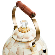 MacKenzie Childs | Mocha Check Tea Kettle, 3 QT: A decorative ceramic kettle with a checker glaze, brass-tone handle with wooden grip, and a glass-knobbed lid.