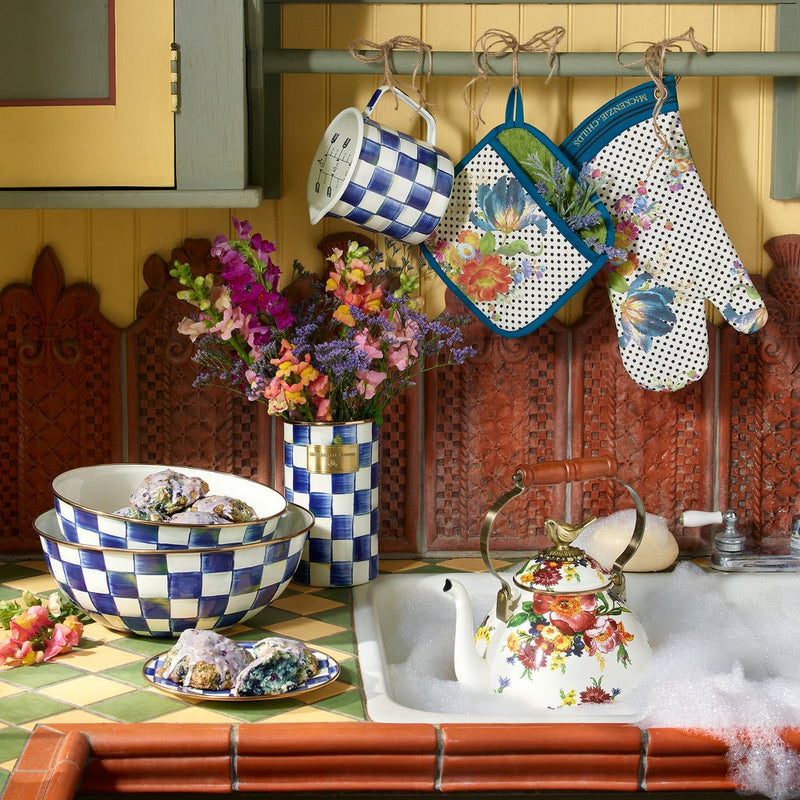 MacKenzie Childs | White Flower Market with Bird Tea Kettle, 3 QT, rests in a sudsy sink, showcasing its floral design and sparrow knob, amid a cozy kitchen setup.