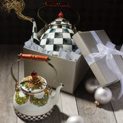MacKenzie Childs | Courtly Check Tea Kettle, 3 QT., featuring bold checkerboard and festive design, displayed with Christmas ornaments on a rustic wooden surface.