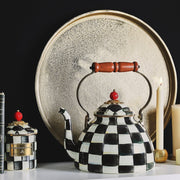 MacKenzie Childs | Courtly Check Tea Kettle, 3 QT., displayed with matching jar, books, gold tray, and candles, showcasing Athens Cooks' whimsical kitchen style.