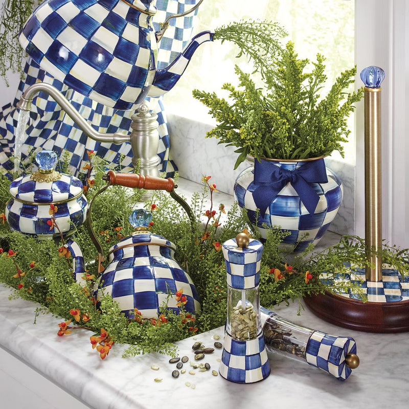 MacKenzie Childs | Royal Check Tea Kettle, 2 QT., with blue-and-white checks, complements a decorative vignette of ceramics and foliage on a marble-top sink area.