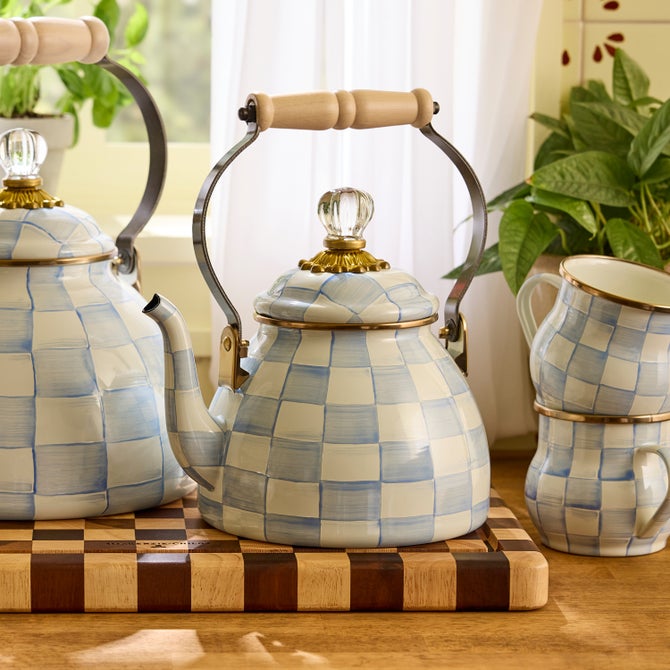 MacKenzie-Childs Sky Check Tea Kettle, 2 Qt, with wooden handle and glass-knob lid, set with matching mugs on a striped cutting board.