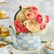MacKenzie-Childs Sky Check Tea Kettle, 2 Qt, repurposed as a floral vase, sits amid a spring tea display with cupcakes and meringues.