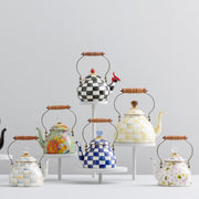 MacKenzie Childs Wildflowers Pink Tea Kettle, 2 QT., featuring hand-applied floral designs, pink splots, a wood handle, and glass-topped lid, displayed on a white plinth.