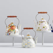 MacKenzie Childs | Sterling Check Tea Kettle, 2 QT., with hand-painted checks, wooden handle, and glass knob, displayed among decorative porcelain teapots on white pedestals.