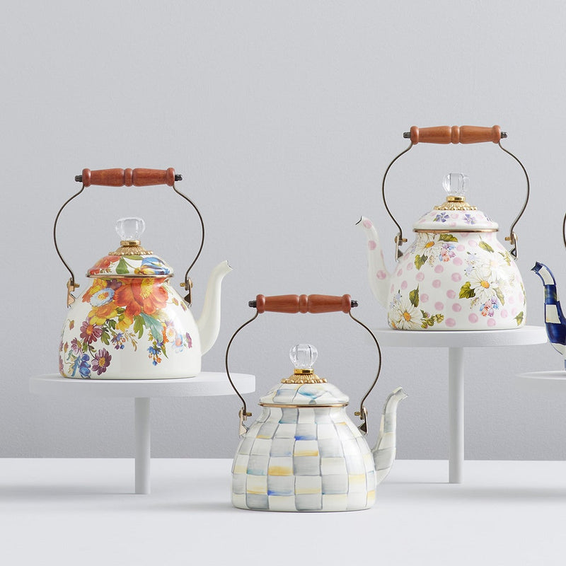 MacKenzie Childs | Sterling Check Tea Kettle, 2 QT., with hand-painted checks, wooden handle, and glass knob, displayed among decorative porcelain teapots on white pedestals.