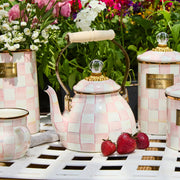 MacKenzie Childs | Rosy Check Tea Kettle, 2 QT, elegantly displayed with matching canisters and teacup, surrounded by strawberries and flowers on a garden-themed tabletop.