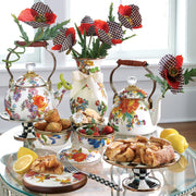 MacKenzie Childs | White Flower Market 2 Quart Tea Kettle amid a vintage floral tea spread with pastries and strawberries, showcasing elegant, hand-glazed steel with floral decals.