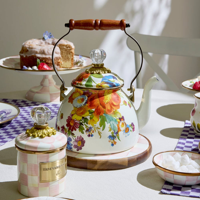 MacKenzie Childs | White Flower Market 2 Quart Tea Kettle with floral design, glass knob, and wood handle, set amid afternoon tea essentials on a tablecloth.