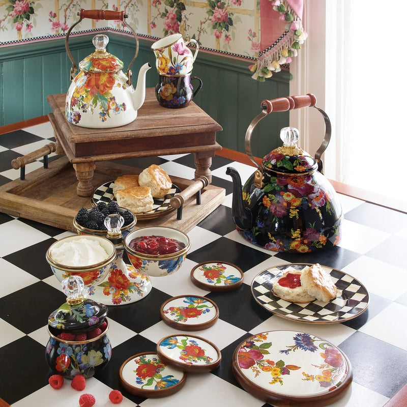 MacKenzie Childs | White Flower Market 2 Quart Tea Kettle on a checkerboard table with floral teapots, scones, and matching floral-patterned china, embodying vintage English-tea style.