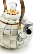 MacKenzie Childs | Sterling Check Whistling Tea Kettle with hand-painted grey checks, metal handle, and flip-up spout cover, featuring a clear glass knob.