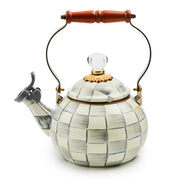 MacKenzie Childs | Sterling Check Whistling Tea Kettle with a checkered body, wooden handle, and flip-top whistle cap. Hand-painted, steel underbody with glass knob.