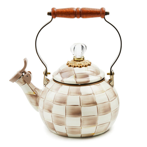 MacKenzie-Childs Mocha Check Whistling Tea Kettle with hand-painted checkerboard, gold-tone accents, wooden handle, and flip-up spout cover, reflecting elegant craftsmanship.