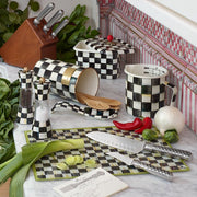 MacKenzie-Childs Courtly Check Recipe Box on checkered kitchenware display, surrounded by fresh produce, knives, and utensils, perfectly blending functionality and elegance in a curated kitchen setting.