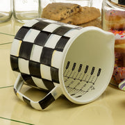 MacKenzie-Childs Courtly Check 7 Cup Measuring Cup on tiled countertop, showcasing its checkered design and measurement markings, ideal for large-batch cooking.