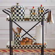 Two-tiered cart with MacKenzie Childs Courtly Check Utensil Holder, copper pans, and kitchen accessories, showcasing Athens Cooks' curated kitchen essentials.
