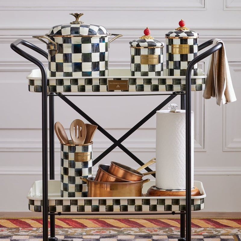 Two-tiered cart with MacKenzie Childs Courtly Check Utensil Holder, copper pans, and kitchen accessories, showcasing Athens Cooks' curated kitchen essentials.